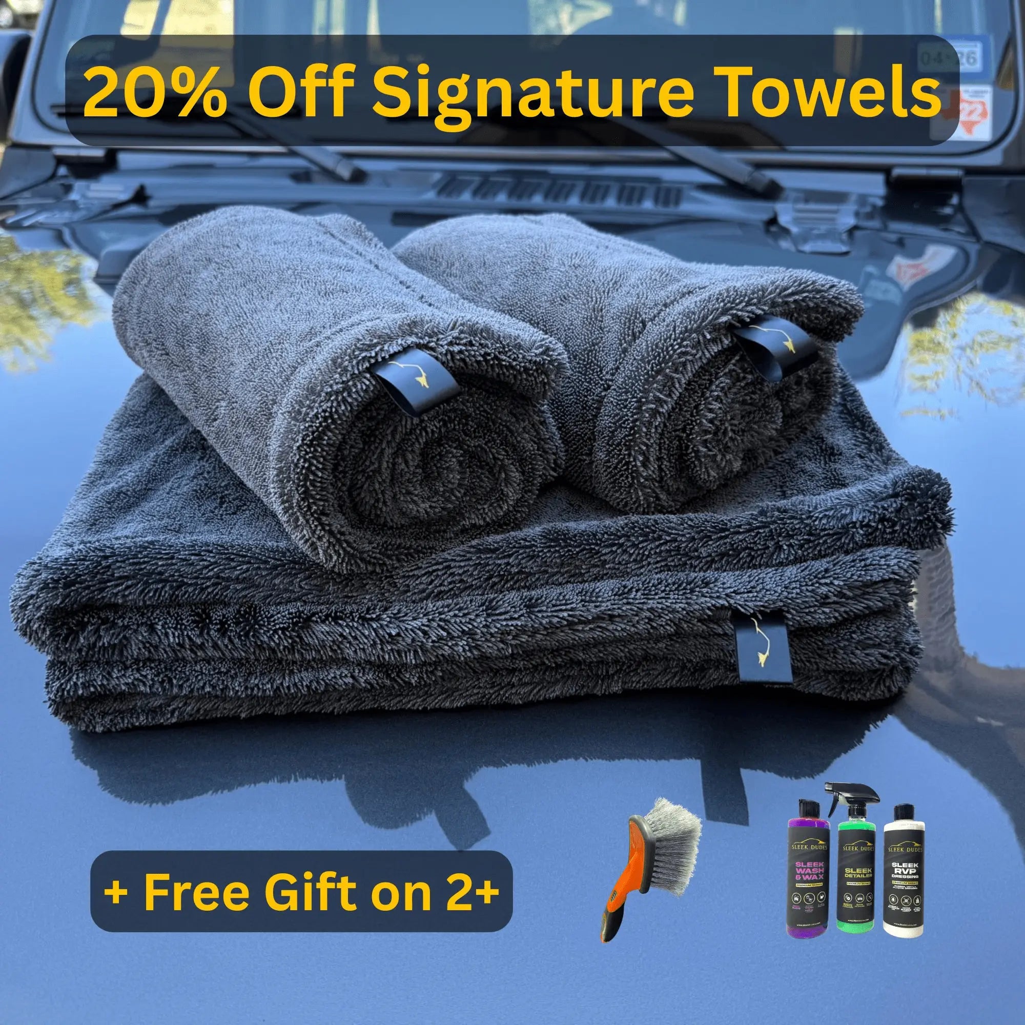 Sleek Dudes folded car towels on a car hood with promotional text and car care products below.