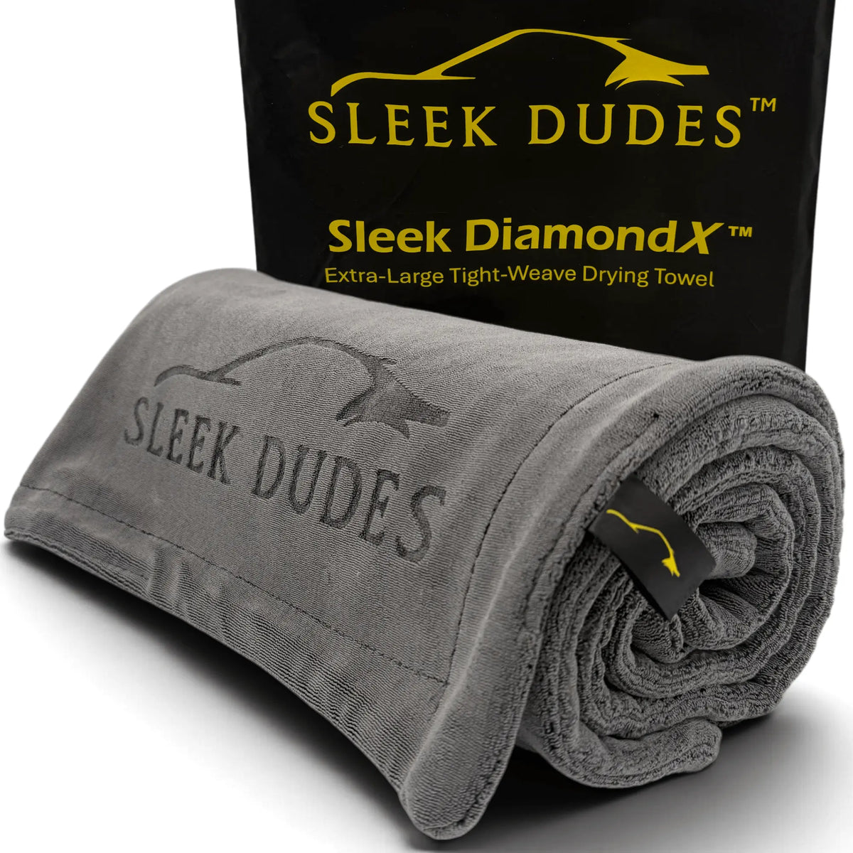 A rolled gray microfiber drying towel with debossed 'SLEEK DUDES' branding, shown in front of its black branded packaging box. The box features yellow text reading 'SLEEK DIAMOND X' and 'Extra-Large Tight-Weave Drying Towel'.
