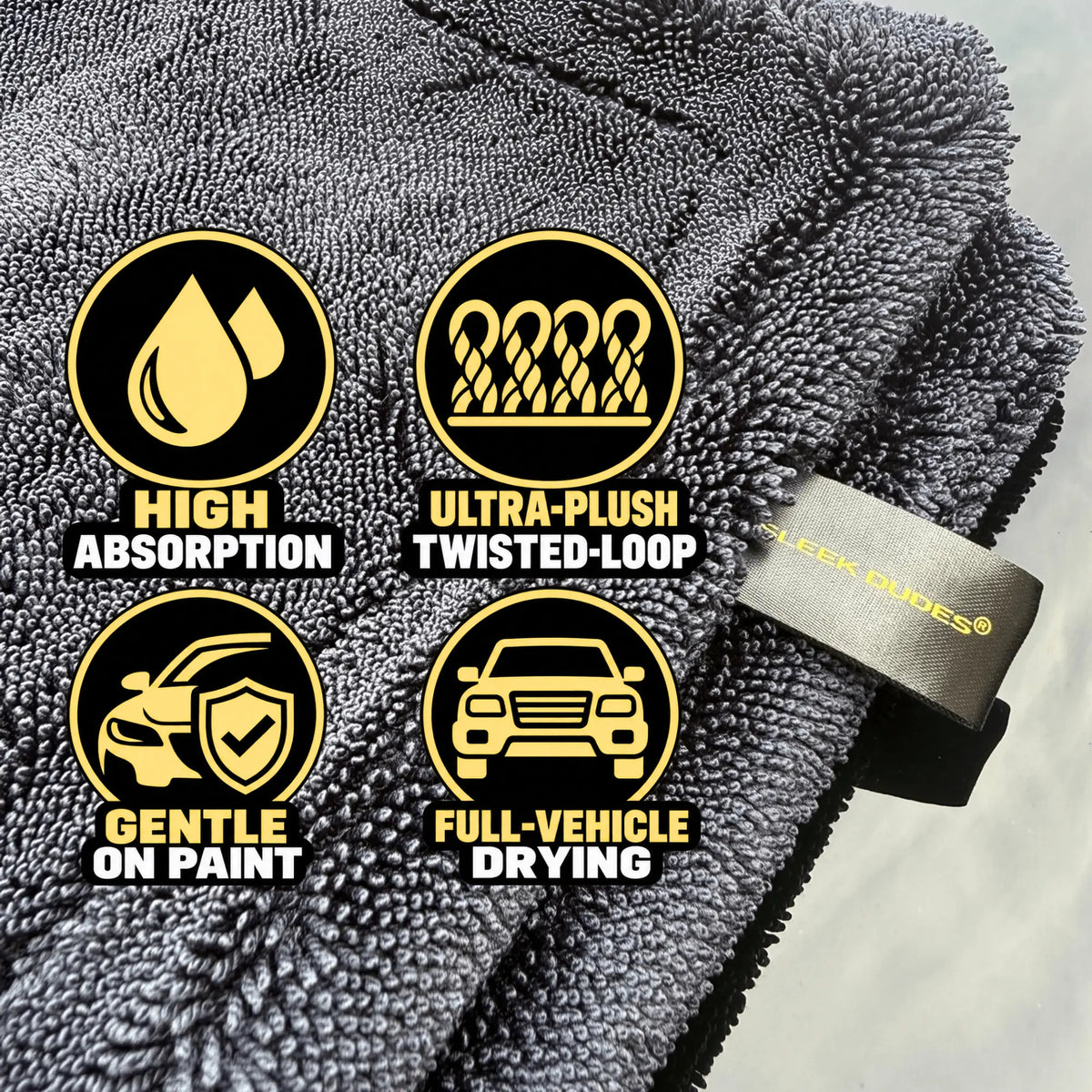 Close-up of a dark gray microfiber car drying towel with four circular feature callouts reading High Absorption, Ultra-Plush Twisted-Loop, Gentle on Paint, and Full-Vehicle Drying. A small visible brand tab reads Seek Roads.