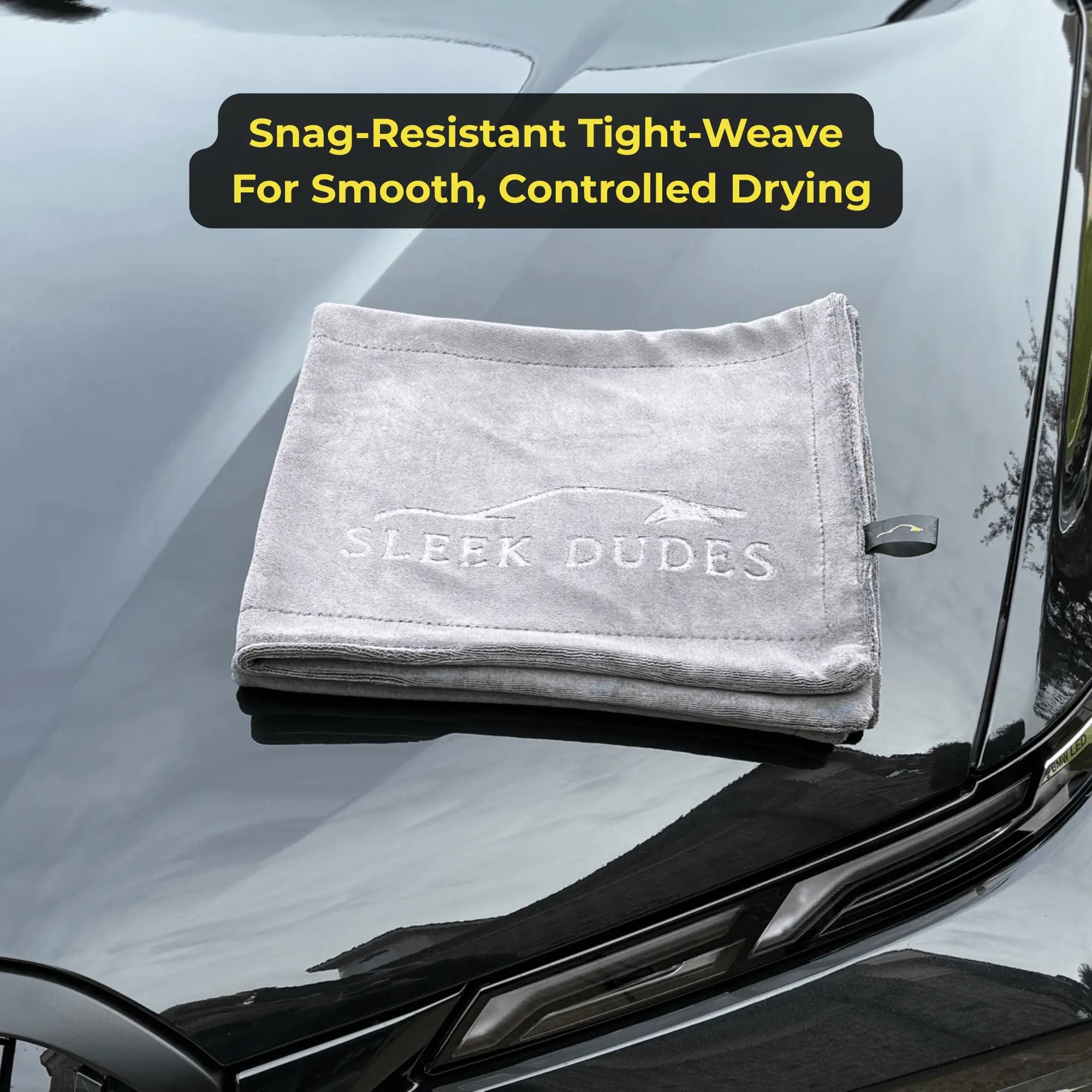 Gray towel with 'Sleek Dudes' branding on a car windshield, text about towel features.