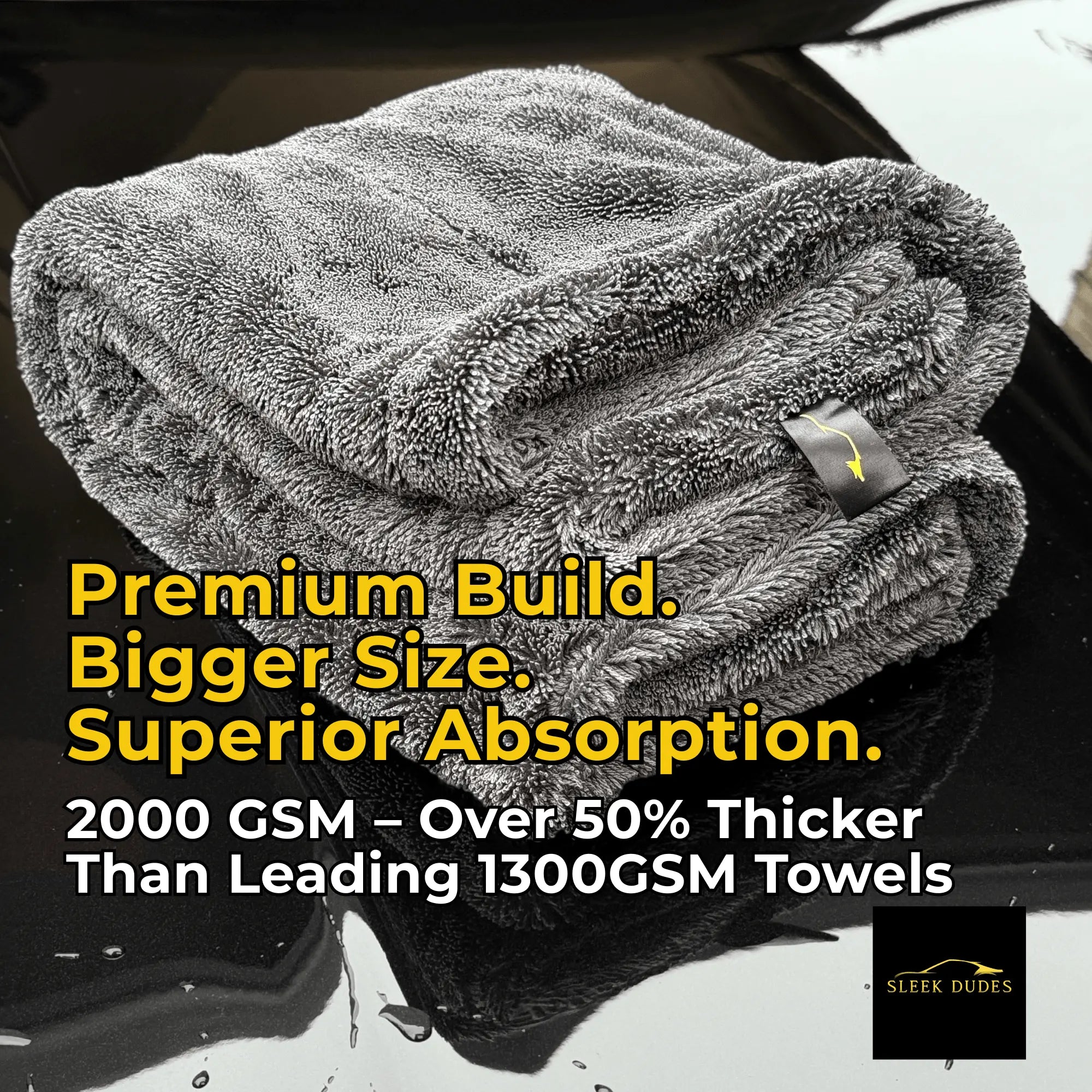 Folded 2000GSM Microfiber drying towel by Sleek Dudes on a black car hood with promotional text