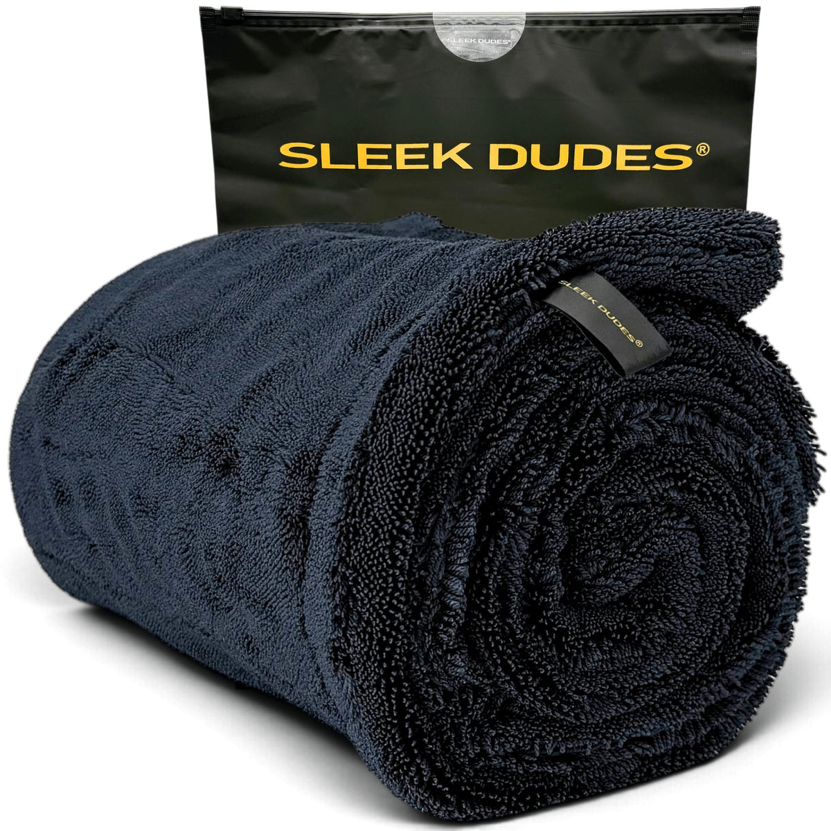 A rolled dark navy blue microfiber towel , shown in front of its black drawstring pouch. The pouch features the brand name 'SLEEK DUDES' printed in yellow.