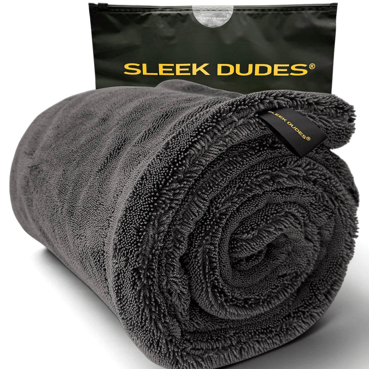 A gray rolled microfiber towel, shown in front of its black carrying pouch. The pouch features the brand name 'SLEEK DUDES' printed in yellow.