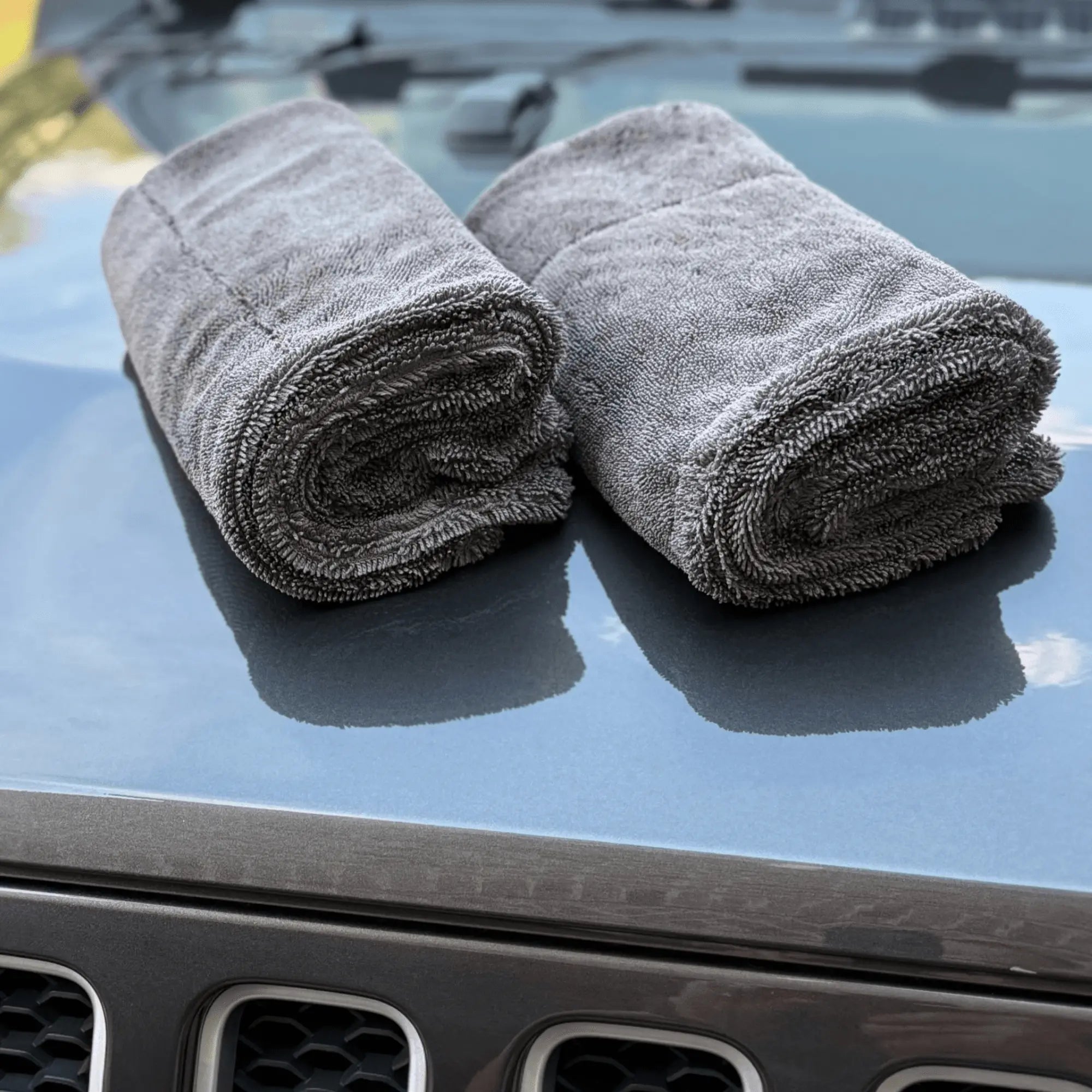 2 Double Trouble towels rolled on a car hood