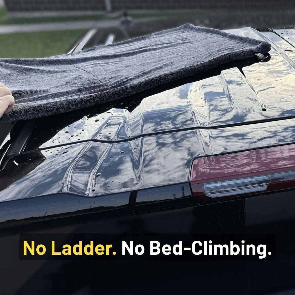 Black car drying towel on a black pickup truck roof, with a hand visible on the left. Text at the bottom reads, 'No Ladder.